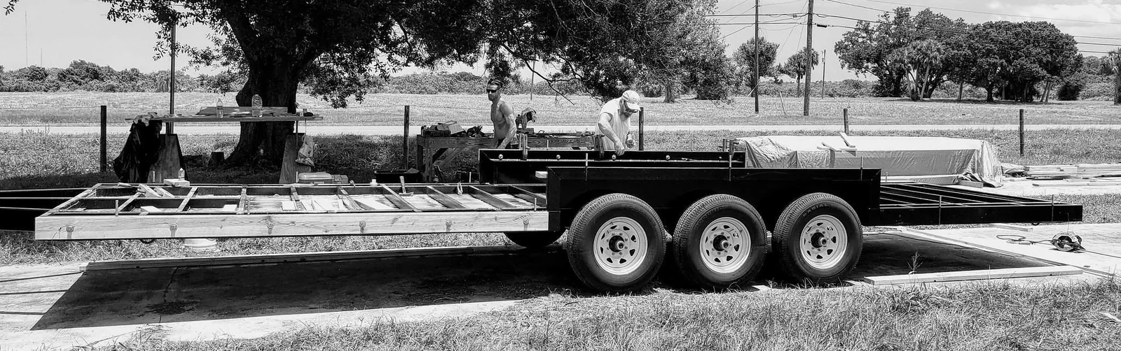 Black-and-white photo of a tiny house trailer frame before construction.